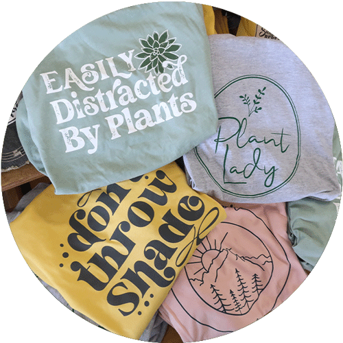 Four t-shirts with sayings on them, including easily distracted by plants, plant lady, and dont throw shade.